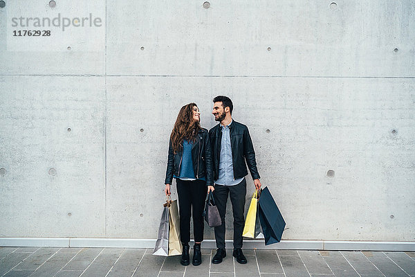 Paar mit Einkaufstaschen  grauer Wandhintergrund  Florenz  Italien