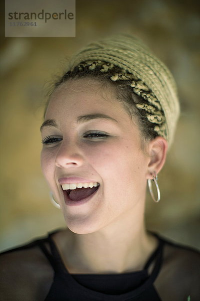 Porträt einer jungen Frau mit Dreadlocks  lachend
