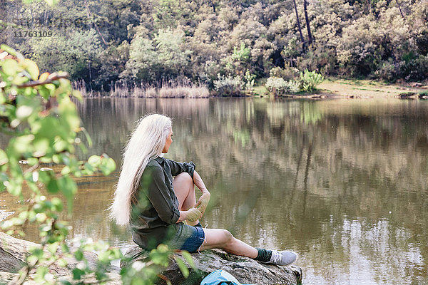 Ältere Backpackerin schaut vom Flussufer im Wald hinaus  Scandicci  Toskana  Italien