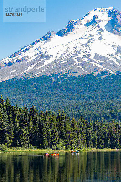 Kanus und Ruderboot auf dem stillen Wasser des Trillium Lake mit Mount Hood  Teil der Cascade Range  Oregon  Vereinigte Staaten von Amerika  Nordamerika