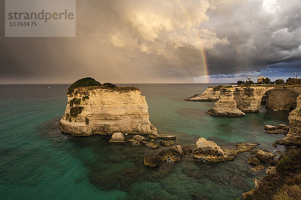 Regenbogenrahmen felsige Klippen  bekannt als Faraglioni di Sant'andrea  umgeben von türkisfarbenem Meer  Provinz Lecce  Apulien  Italien  Europa
