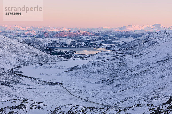 Rosa Himmel bei Sonnenuntergang auf der Schneelandschaft und dem gefrorenen Meer um Fjordbotn  Lysnes  Senja  Troms  Norwegen  Skandinavien  Europa