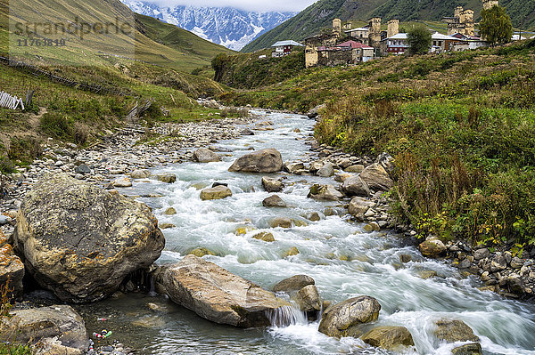 Der Fluss Patara Enguri und die traditionellen mittelalterlichen wanetischen Turmhäuser  Dorf Ushguli  dahinter das Shkhara-Gebirge  Region Svaneti  Georgien  Kaukasus  Asien