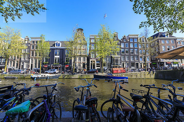 Am Ufer der Amstel geparkte Fahrräder und typische Häuser  Amsterdam  Holland (Niederlande)  Europa