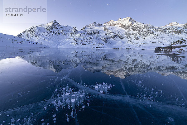 Eisblasen umrahmen die verschneiten Gipfel  die sich im Lago Bianco spiegeln  Berninapass  Kanton Graubünden  Engadin  Schweiz  Europa