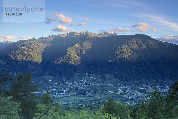 Blick von oben auf das Dorf Bianzone  eingerahmt von den felsigen Gipfeln der Rätischen Alpen in der Morgendämmerung  Valtellina  Lombardei  Italien  Europa