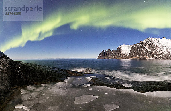 Panorama des gefrorenen Meeres und der felsigen Gipfel  die vom Nordlicht (Aurora Borealis) erleuchtet werden  Tungeneset  Senja  Troms  Norwegen  Skandinavien  Europa