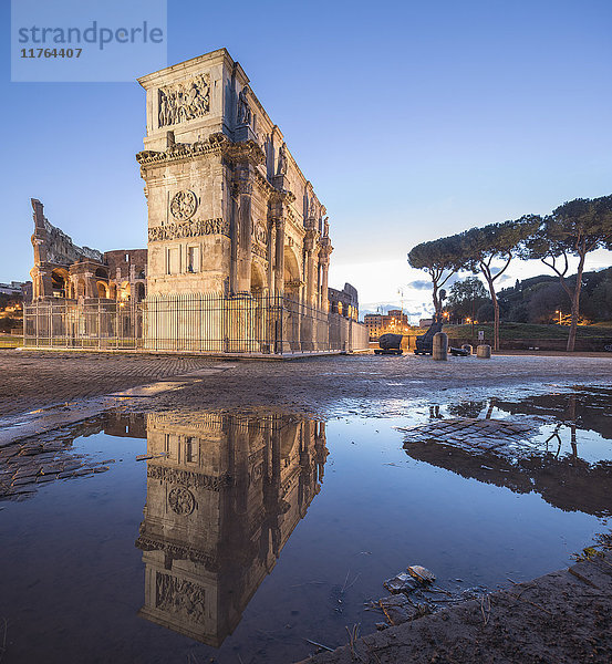 Der historische Konstantinbogen spiegelt sich in einer Pfütze in der Abenddämmerung  Rom  Latium  Italien  Europa