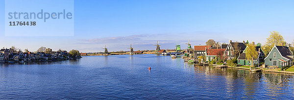 Panorama von Holzhäusern und Windmühlen  eingerahmt vom blauen Fluss Zaan  Zaanse Schans  Nordholland  Niederlande  Europa