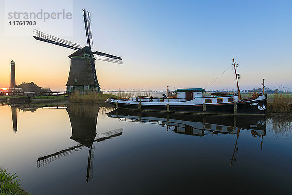 Typische Windmühle  die sich in der Morgendämmerung in der Gracht spiegelt  Berkmeer  Gemeinde Koggenland  Nordholland  Niederlande  Europa