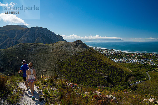 Mann und Frau wandern vom Berg hinunter nach Hermanus  Hermanus  Südafrika  Afrika