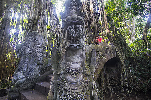 Sehr schöne geschnitzte Brücke mit überwuchernden Bäumen  Sacred Monkey Forest Sanctuary  Ubud  Bali  Indonesien  Südostasien  Asien