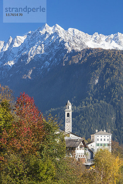 Die bunten Bäume umrahmen die Alpenkirche und die verschneiten Gipfel  Soglio  Bergell  Kanton Graubünden  Schweizer Alpen  Schweiz  Europa
