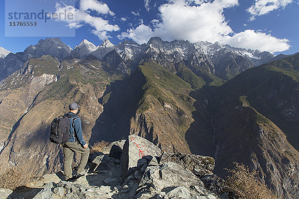 Mann beim Wandern in der Tiger Leaping Gorge  UNESCO-Weltkulturerbe  mit dem Jadedrachen-Schneeberg (Yulong Xueshan)  Yunnan  China  Asien