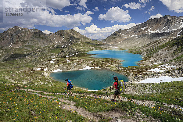 Wanderer passieren den türkisfarbenen See und felsige Gipfel  Joriseen  Jorifless Pass  Kanton Graubünden  Engadin  Schweiz  Europa