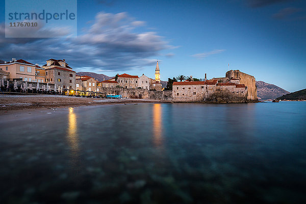 Eine Langzeitbelichtung während der abendlichen blauen Stunde des Strandes und des Stari Grad (Altstadt) von Budva  Montenegro  Europa