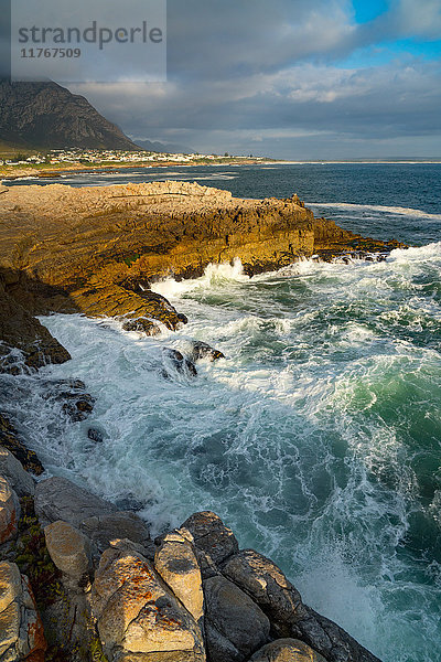 Meereslandschaft mit stürmischer See und Felsen in der untergehenden Sonne am Sievers Point  Hermanus  Südafrika  Afrika