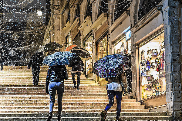 Menschen auf der Rialto-Brücke mit Regenschirmen bei seltenem Schneefall  Winterabend  Venedig  UNESCO-Weltkulturerbe  Venetien  Italien  Europa