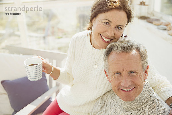 Portrait lächelndes reifes Paar beim Umarmen und Kaffeetrinken