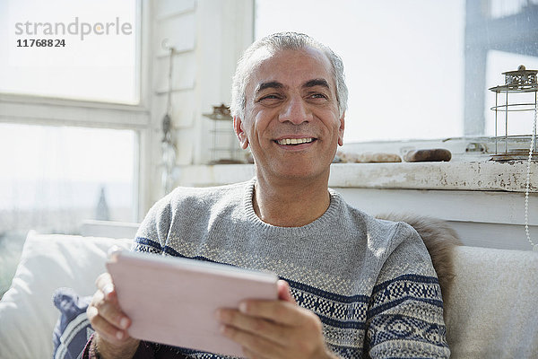 Portrait lächelnder älterer Mann mit digitalem Tablett