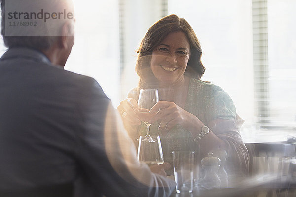 Lächelndes reifes Paar trinkt Wein  speist am Restauranttisch