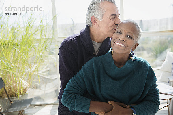 Portrait liebevolles Seniorenpaar umarmend und küssend