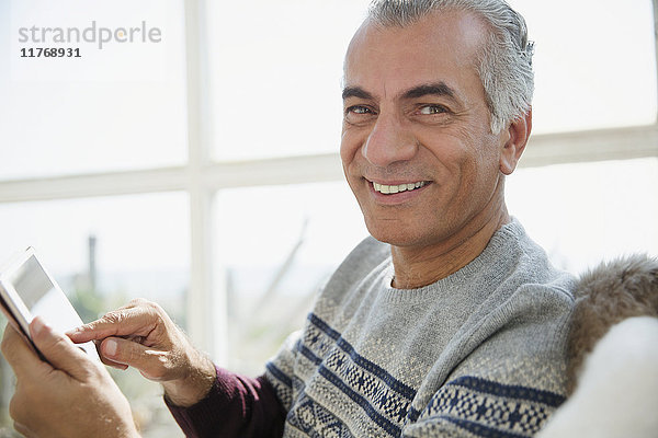 Portrait lächelnder älterer Mann mit digitalem Tablett