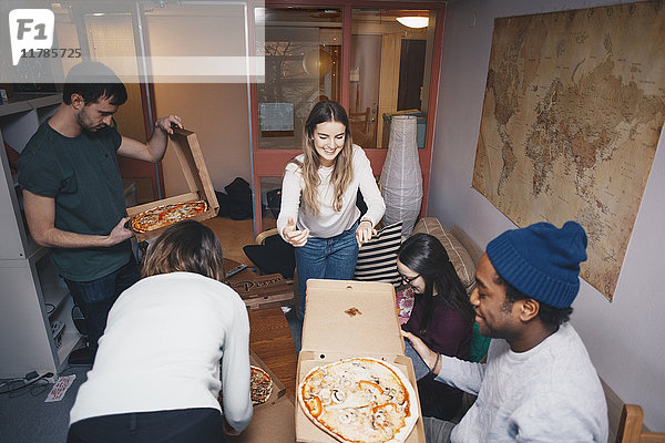 Blick von jungen Freunden auf die Pizza-Party im Studentenwohnheim