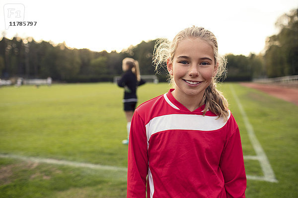 Porträt eines fröhlichen Fußballmädchens auf dem Spielfeld