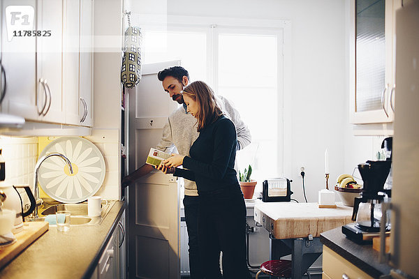 Frau zeigt dem Mann in der Küche zu Hause Lebensmittelverpackung