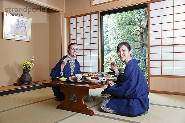 Weiße Frau in Yukata beim Essen mit japanischem Freund in einem traditionellen Ryokan  Tokio  Japan