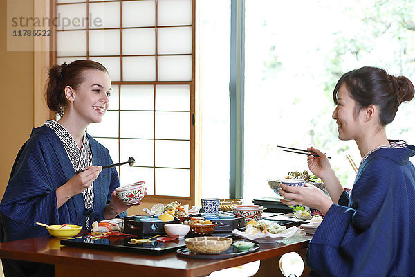 Weiße Frau in Yukata beim Essen mit japanischem Freund in einem traditionellen Ryokan  Tokio  Japan