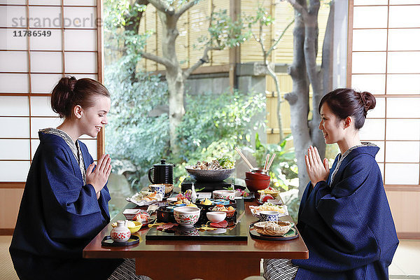 Weiße Frau in Yukata beim Essen mit japanischem Freund in einem traditionellen Ryokan  Tokio  Japan