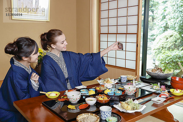 Weiße Frau in Yukata isst mit japanischem Freund in einem traditionellen Ryokan  Tokio  Japan