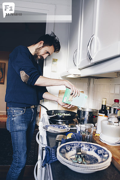Seitenansicht des Mannes beim Kochen in der Küche zu Hause