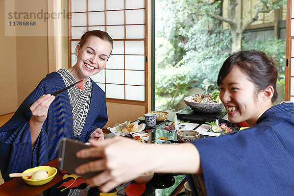 Weiße Frau in Yukata beim Essen mit japanischem Freund in einem traditionellen Ryokan  Tokio  Japan