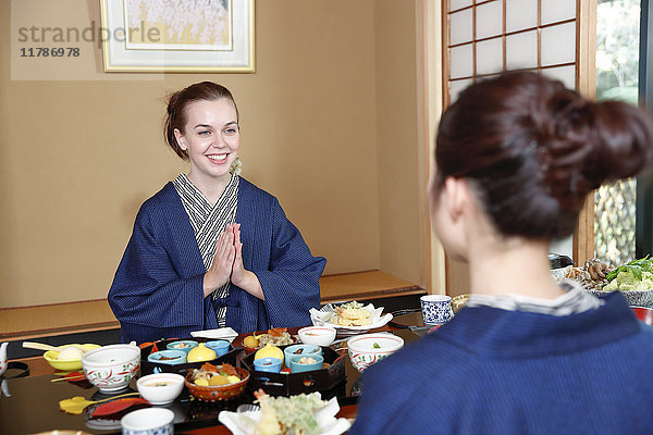 Weiße Frau in Yukata beim Essen mit japanischem Freund in einem traditionellen Ryokan  Tokio  Japan