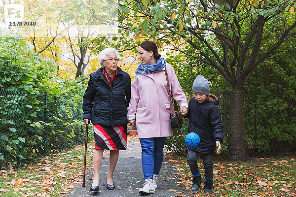 Volle Länge der älteren Frau  die mit Tochter und Urenkel im Park läuft.