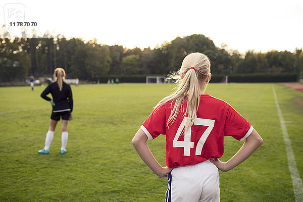 Rückansicht des auf dem Fußballplatz stehenden Mädchens