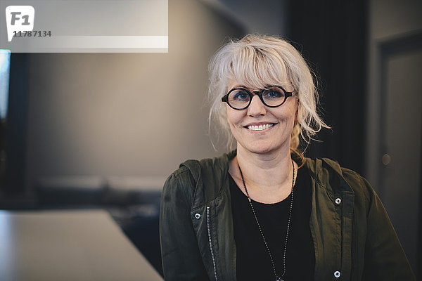 Porträt einer glücklichen Geschäftsfrau mit Brille im Büro