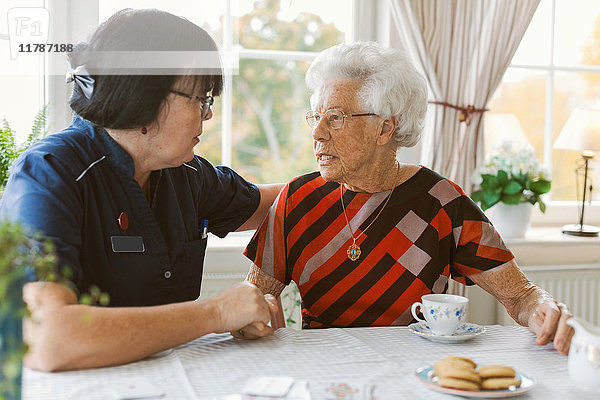Hausmeisterin tröstet Seniorin im Pflegeheim