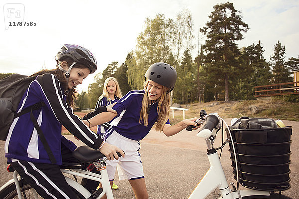 Fröhliche Freunde genießen mit dem Fahrrad auf dem Fußweg