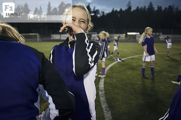 Fröhliches Mädchen bei Freunden auf dem Fußballfeld