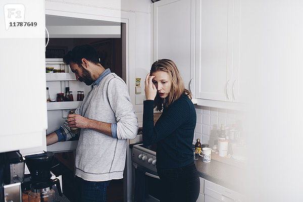 Mann und Frau stehen in der Küche zu Hause