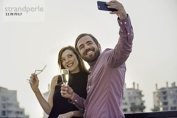 Pärchen posieren mit Champagner für Selfie