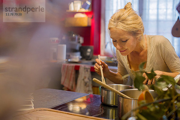 Reife Frau  die beim Kochen Essen riecht