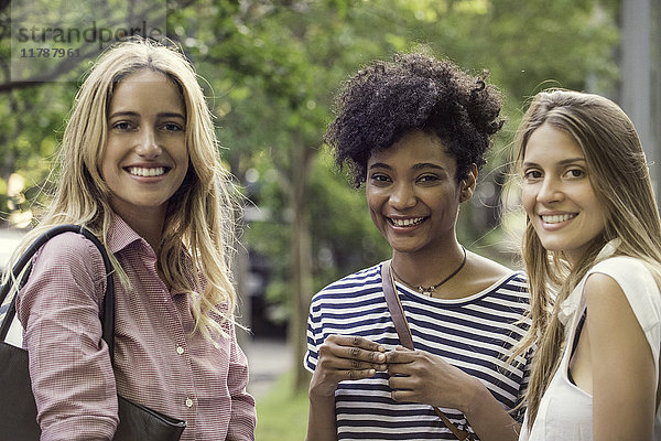 Junge Frauen lächeln gemeinsam im Freien  Porträt