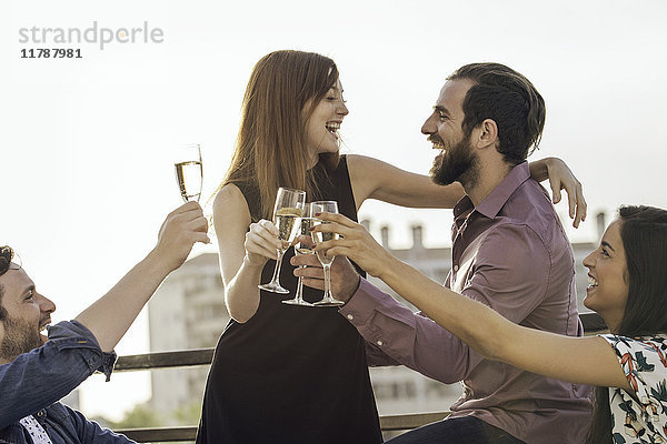 Freunde trinken gemeinsam Champagner im Freien.