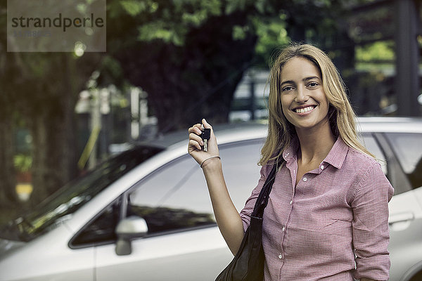 Junge Frau mit Autoschlüsseln  fröhlich lächelnd  Porträt
