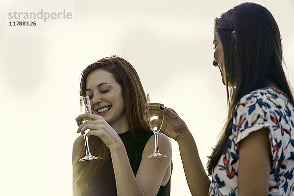 Frau trinkt gemeinsam Champagner im Freien
